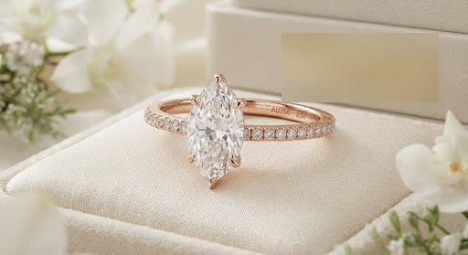 Rose gold solitaire ring with a marquise diamond in a ring box